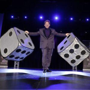 Brian Glow on stage with large dice.